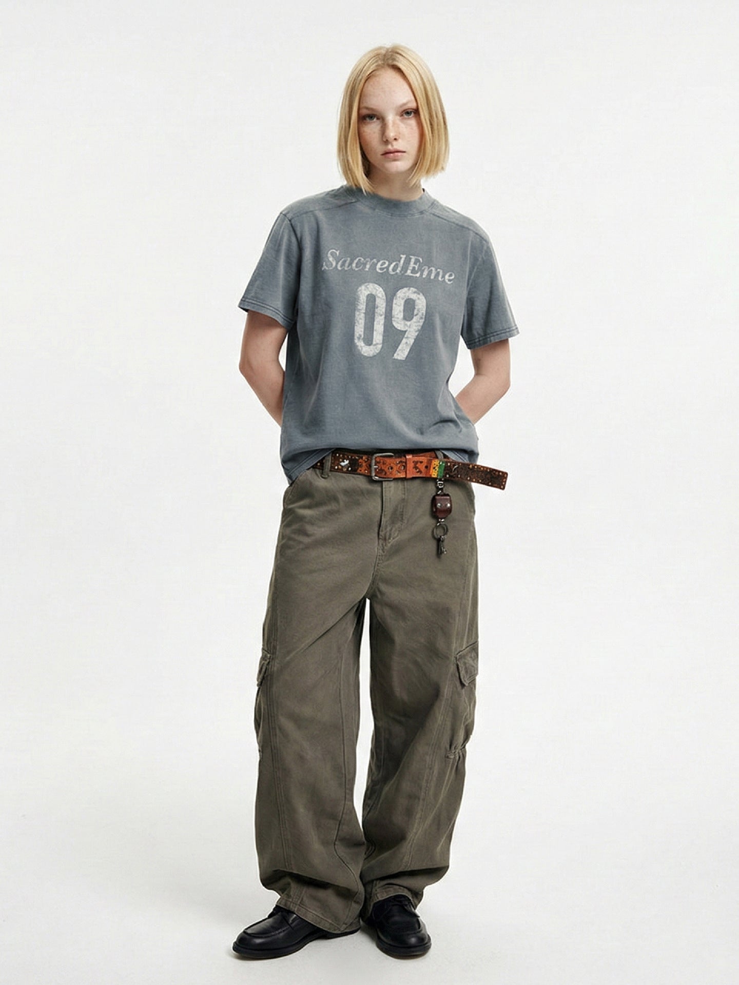 Blue-gray washed graphic T-shirt paired with wide-leg olive cargo pants.