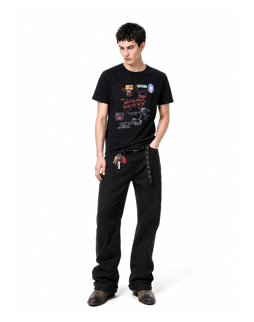 Full body shot of model wearing a black waffle knit graphic tee styled with dark wide-leg jeans.