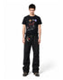 Front full body view of model in a black relaxed-fit waffle knit graphic t-shirt and black trousers.