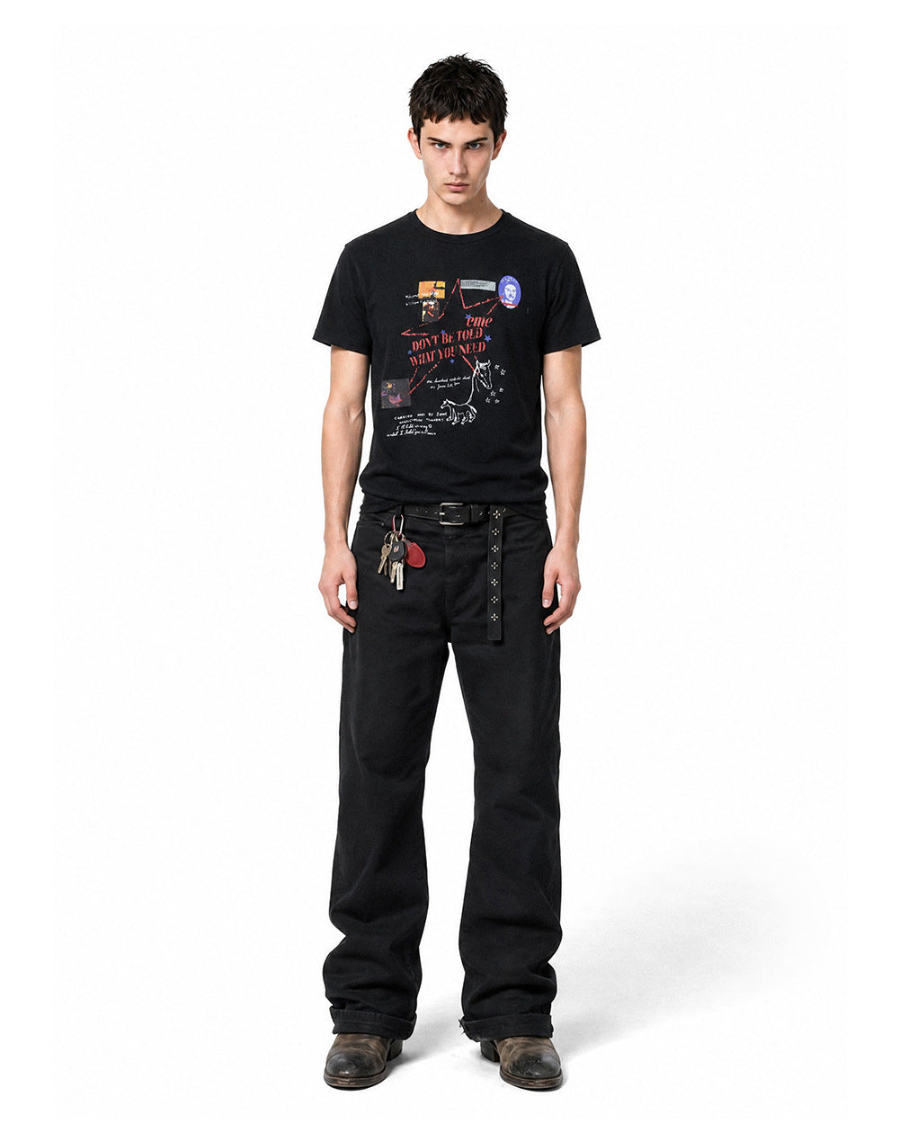Front full body view of model in a black relaxed-fit waffle knit graphic t-shirt and black trousers.