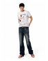 Full body shot of model wearing an off-white waffle knit graphic t-shirt with relaxed blue denim.