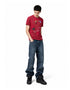 Full length view of model styled in a red graphic waffle tee, loose jeans, and high-top sneakers.