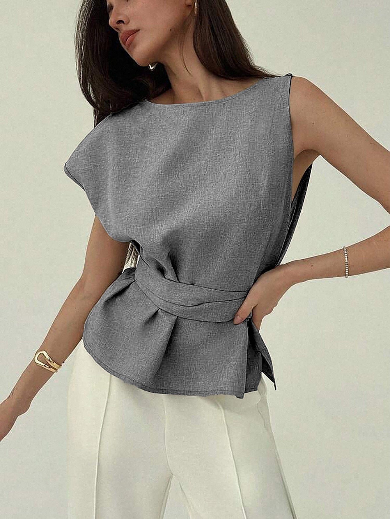 Minimalist belted sleeveless blouse styled with ivory trousers
