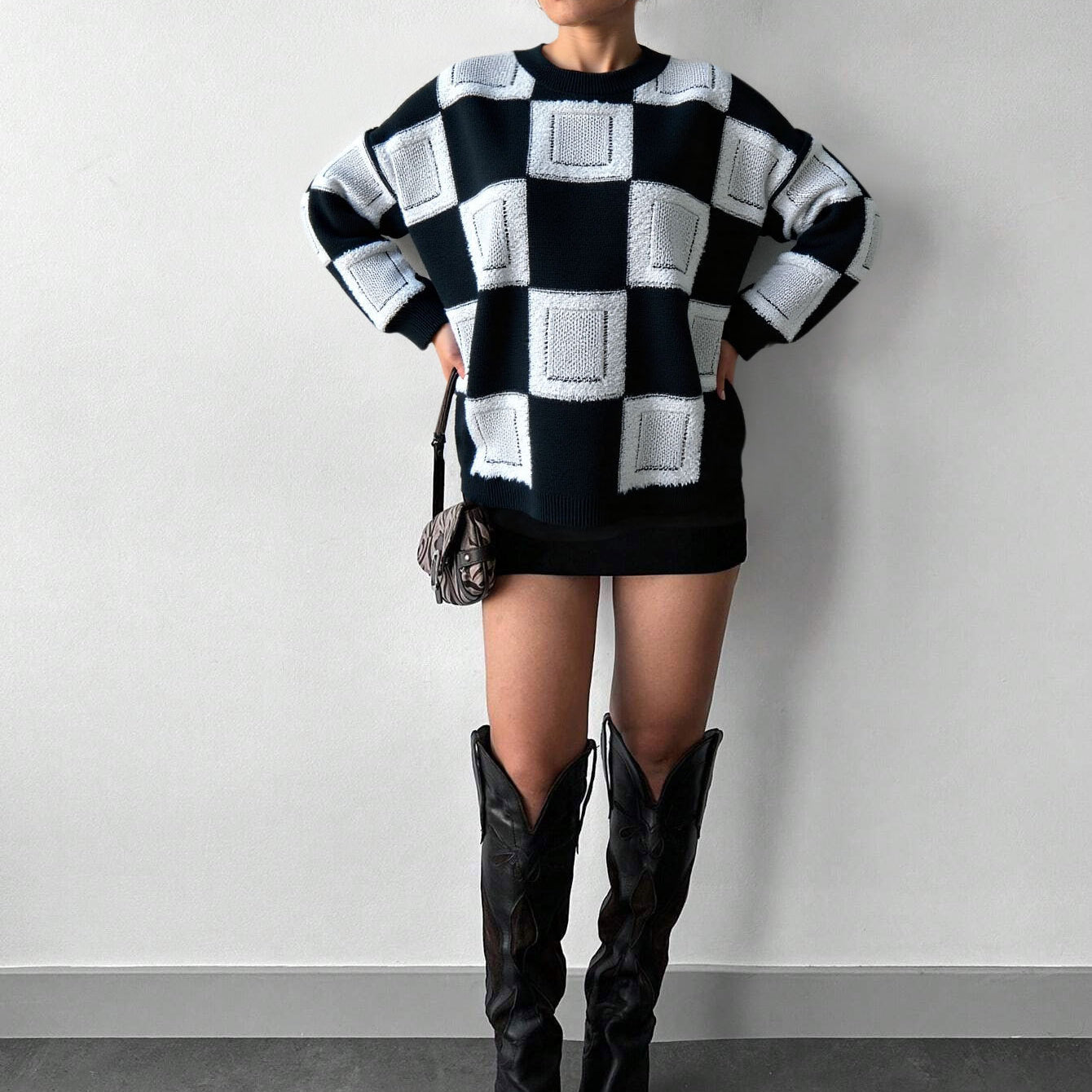 mock neck checkered sweater styled with black boots in minimal studio