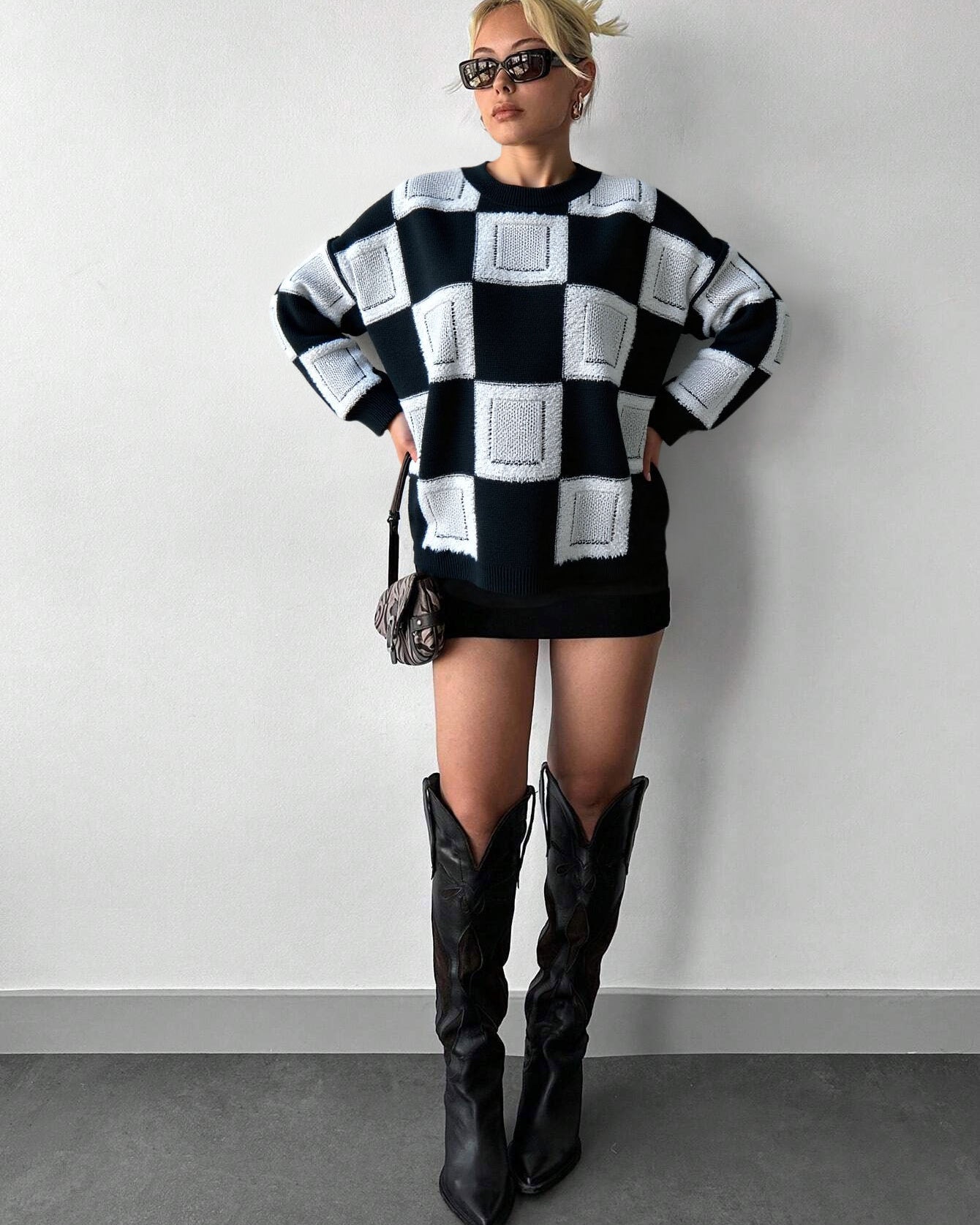 mock neck checkered sweater styled with black boots in minimal studio