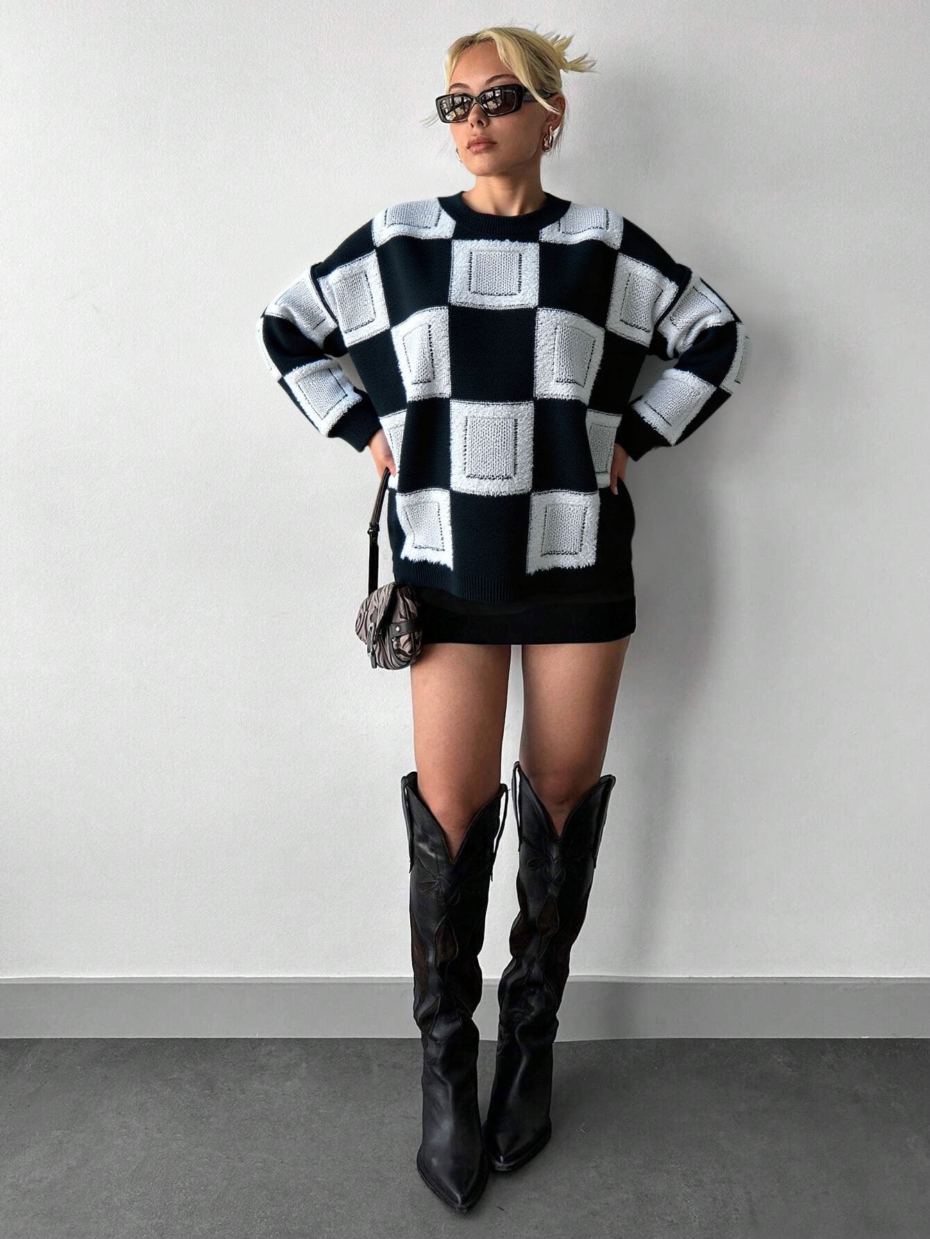 mock neck checkered sweater styled with black boots in minimal studio