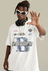 Model in white tee with racing print reaching forward in sunglasses.