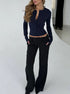 Navy knit cardigan styled with black pants in studio