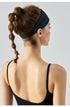 Back view of woman wearing dark navy workout headband.