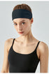 Front view of woman wearing dark navy workout headband.