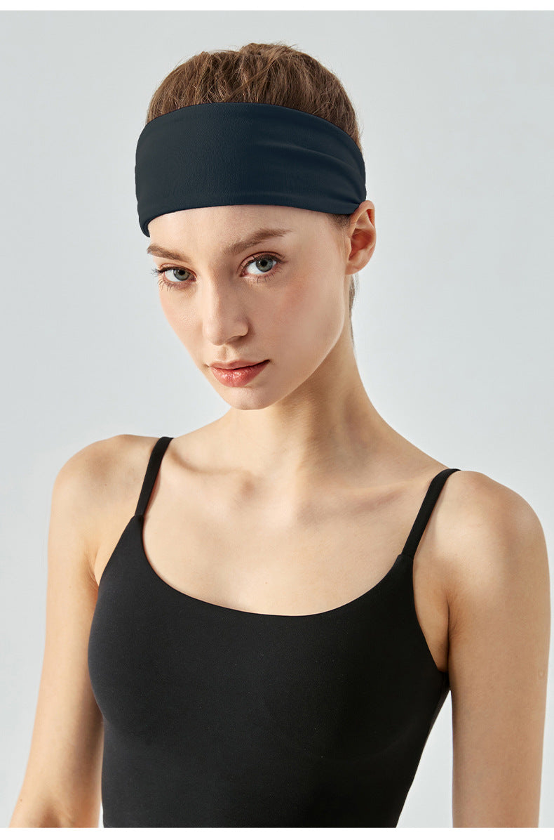 Front view of woman wearing dark navy workout headband.