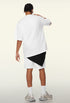 Back view of white oversized tee with layered black detail under shorts