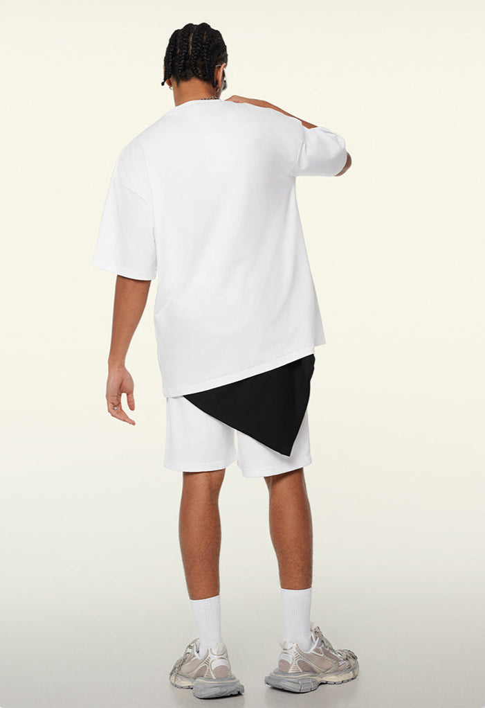 Back view of white oversized tee with layered black detail under shorts