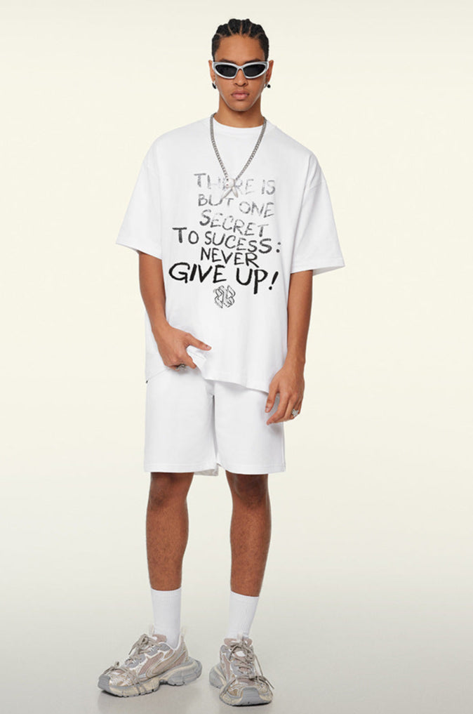 Model in white oversized tee with graphic text, one hand in pocket
