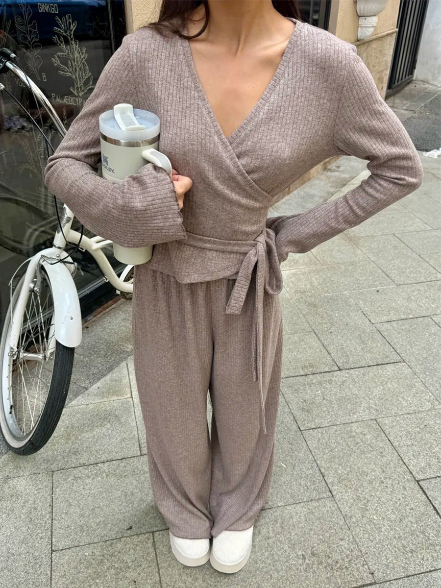 close-up of woman wearing ribbed wrap top sleeve and waist tie with white tumbler