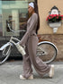 woman wearing oatmeal ribbed lounge set walking beside bicycle