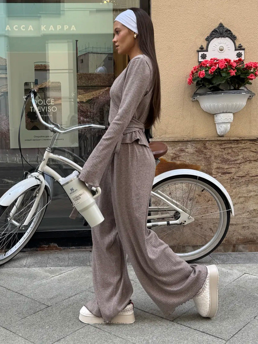 woman wearing oatmeal ribbed lounge set walking beside bicycle