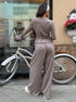 Back view of woman wearing oatmeal ribbed lounge set looking sideways outdoors