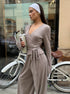 woman wearing oatmeal ribbed wrap crop top and wide leg pants posing beside bicycle