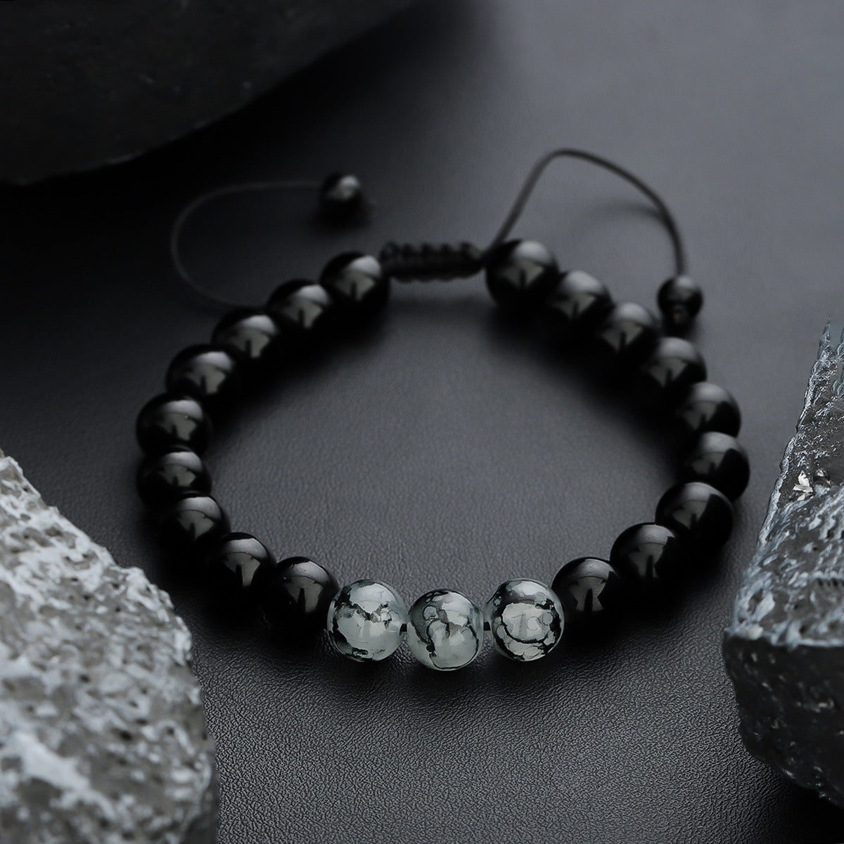 Black bracelet with three natural stone beads.