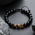 Black beaded bracelet with three tiger eye gemstones.
