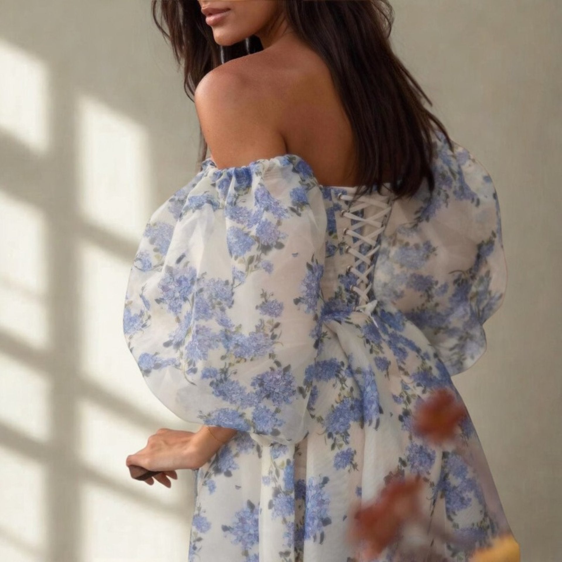 Angled view of woman in off-shoulder puff sleeve floral gown