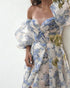 Woman wearing a blue and white floral gown.