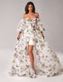 Woman in pink off-shoulder puff sleeve floral gown with high slit and sweetheart neckline.