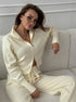 Sitting view of off-white knit 2 piece set with zip jacket and pants