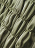 Close-up of ruched satin fabric texture in olive green
