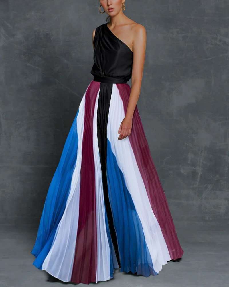 Woman wearing a one-shoulder maxi dress with black, blue, red, and white color block design on a gray background.