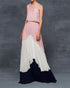 Woman wearing a pink one-shoulder maxi dress with a gradient design against a gray background