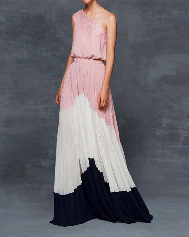 Woman wearing a pink one-shoulder maxi dress with a gradient design against a gray background