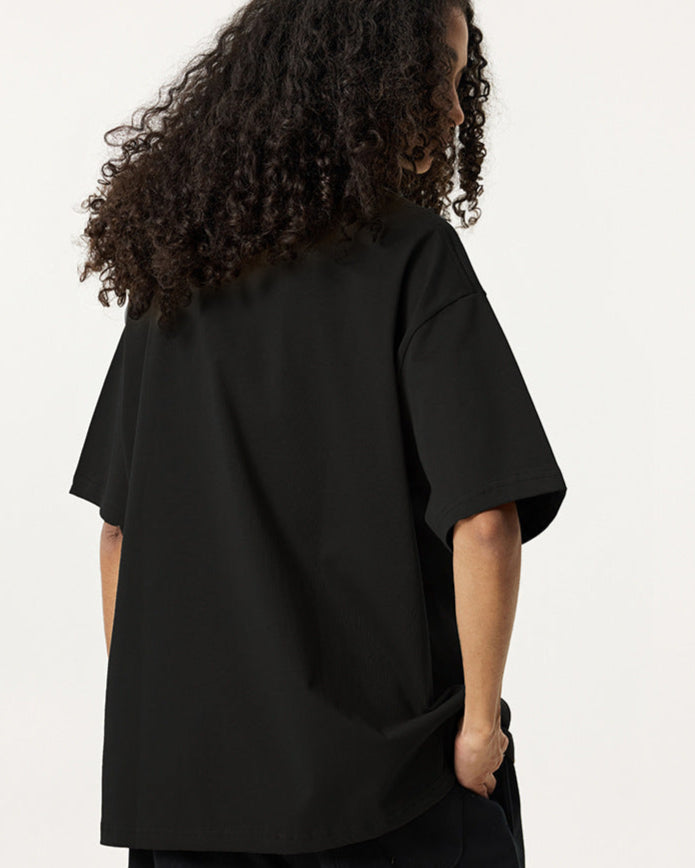 Back view of female model wearing black Ouroboros 8-ball tee