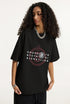 Woman wearing black graphic t-shirt turned slightly to the side.