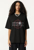 Closeup of woman in black graphic tee with Ouroboros and 8-ball design.