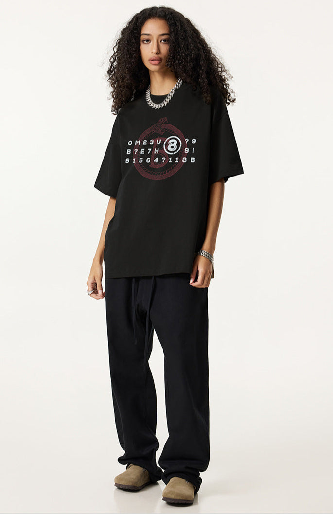 Woman in black oversized Ouroboros 8-ball t-shirt and dark pants.