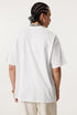 Back view of plain white oversized ouroboros 8ball t-shirt worn by man with braided hair.