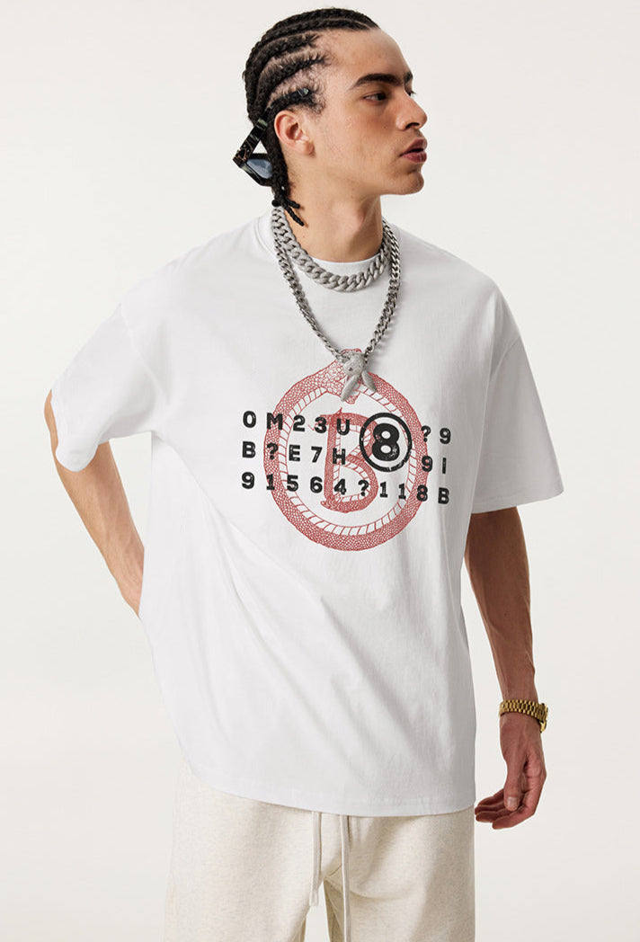 Man in white graphic tee glancing sideways with hands in pockets.