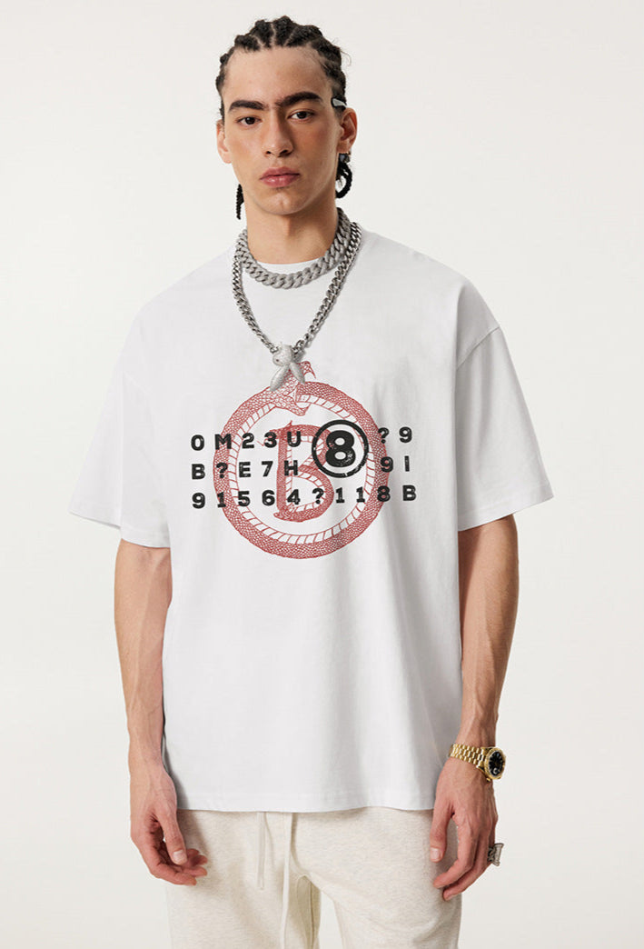 Closeup of man wearing white Ouroboros 8-ball graphic t-shirt with chain necklace.