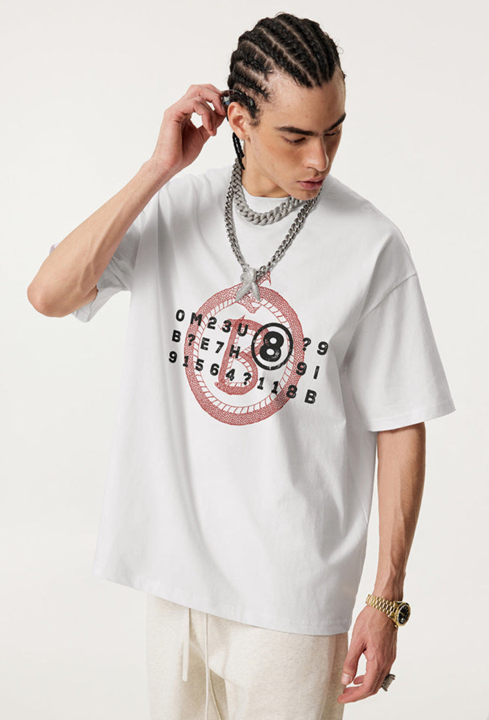 Side view of man in white Ouroboros 8-ball t-shirt adjusting his braids.