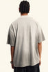 Back view of light grey oversized graphic tee worn by male model.