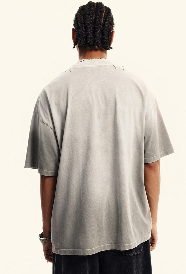 Back view of light grey oversized graphic tee worn by male model.