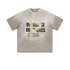 Flat lay of light gray oversized T-shirt with distressed “Overcome Obstacles” and “Nothing is Impossible” text.