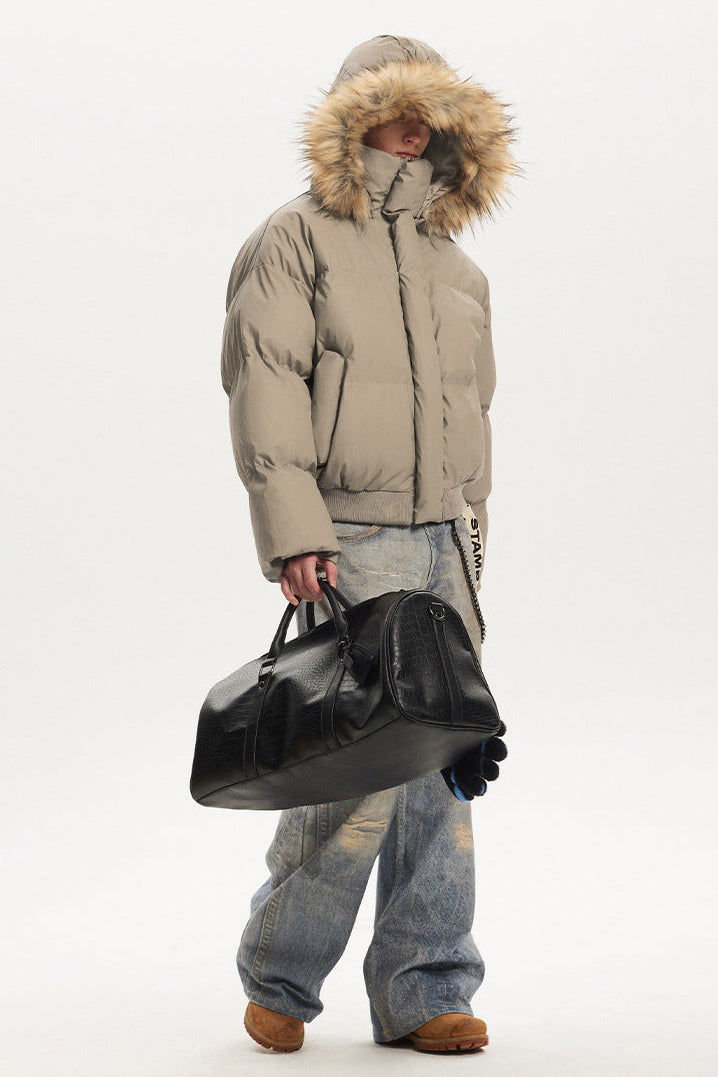 Side view of model wearing a khaki puffer jacket with the plush faux fur hood pulled completely over head.
