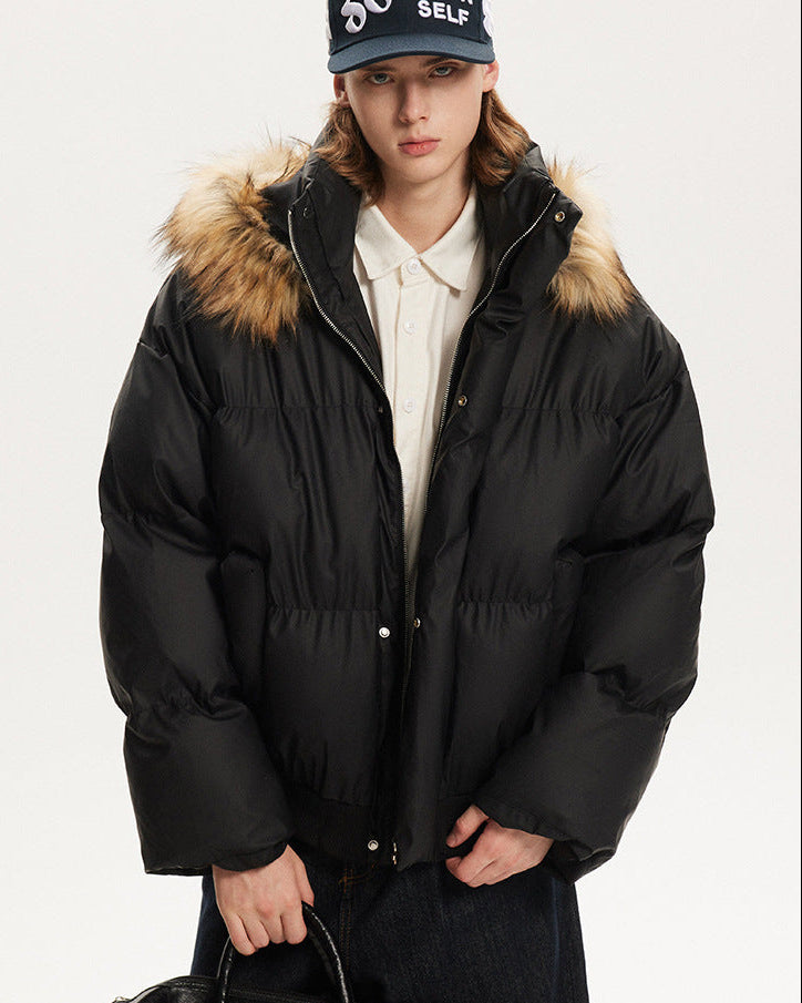 Front portrait view of a model in a black relaxed fit puffer coat with plush hood trim.