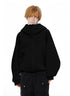 Front view of male model wearing classic black oversized zip up hoodie with high stand collar zipped up.
