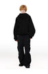 Full length view of male model in black high neck zip up hoodie jacket paired with black wide leg cargo pants.