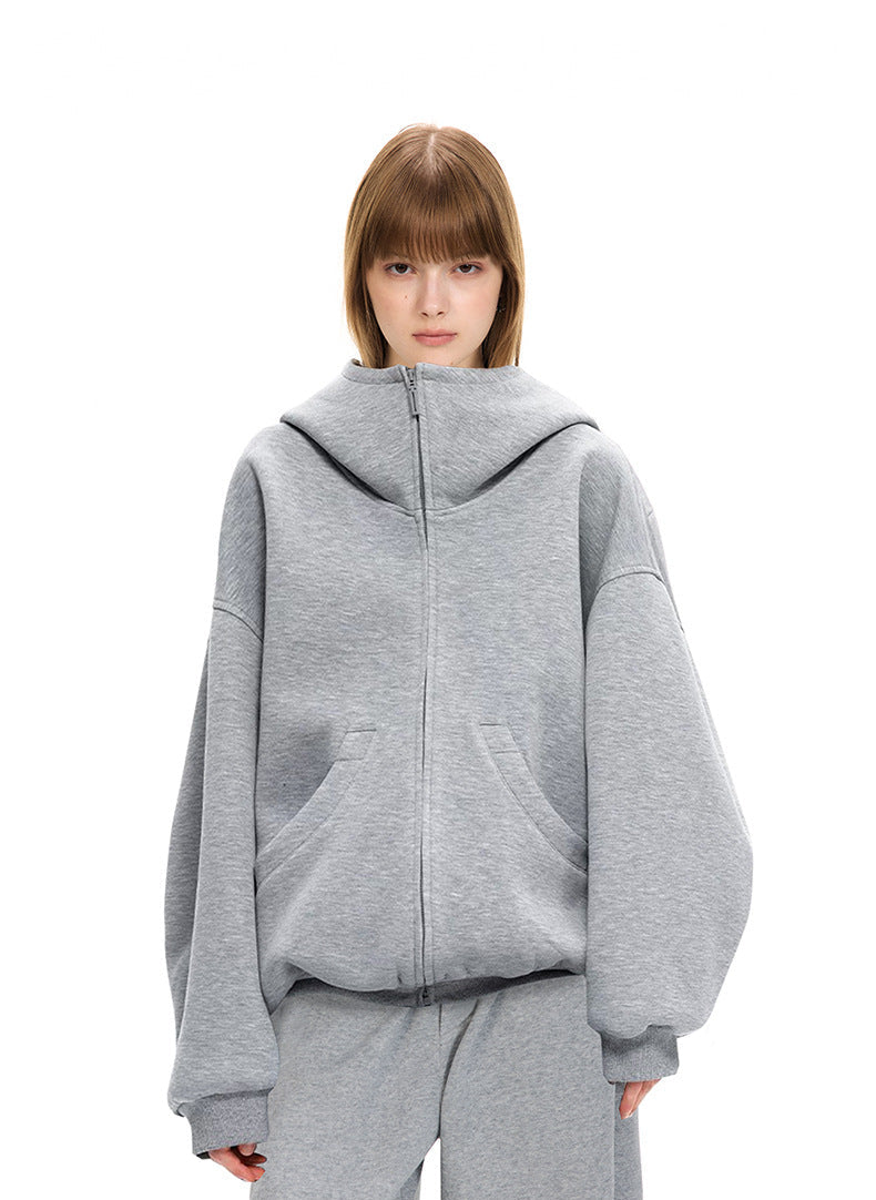 Female model wearing heather gray oversized high neck zip up hoodie in 100% cotton air layer fabric.