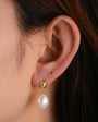 Gold-tone freshwater pearl drop earring worn on ear, side profile